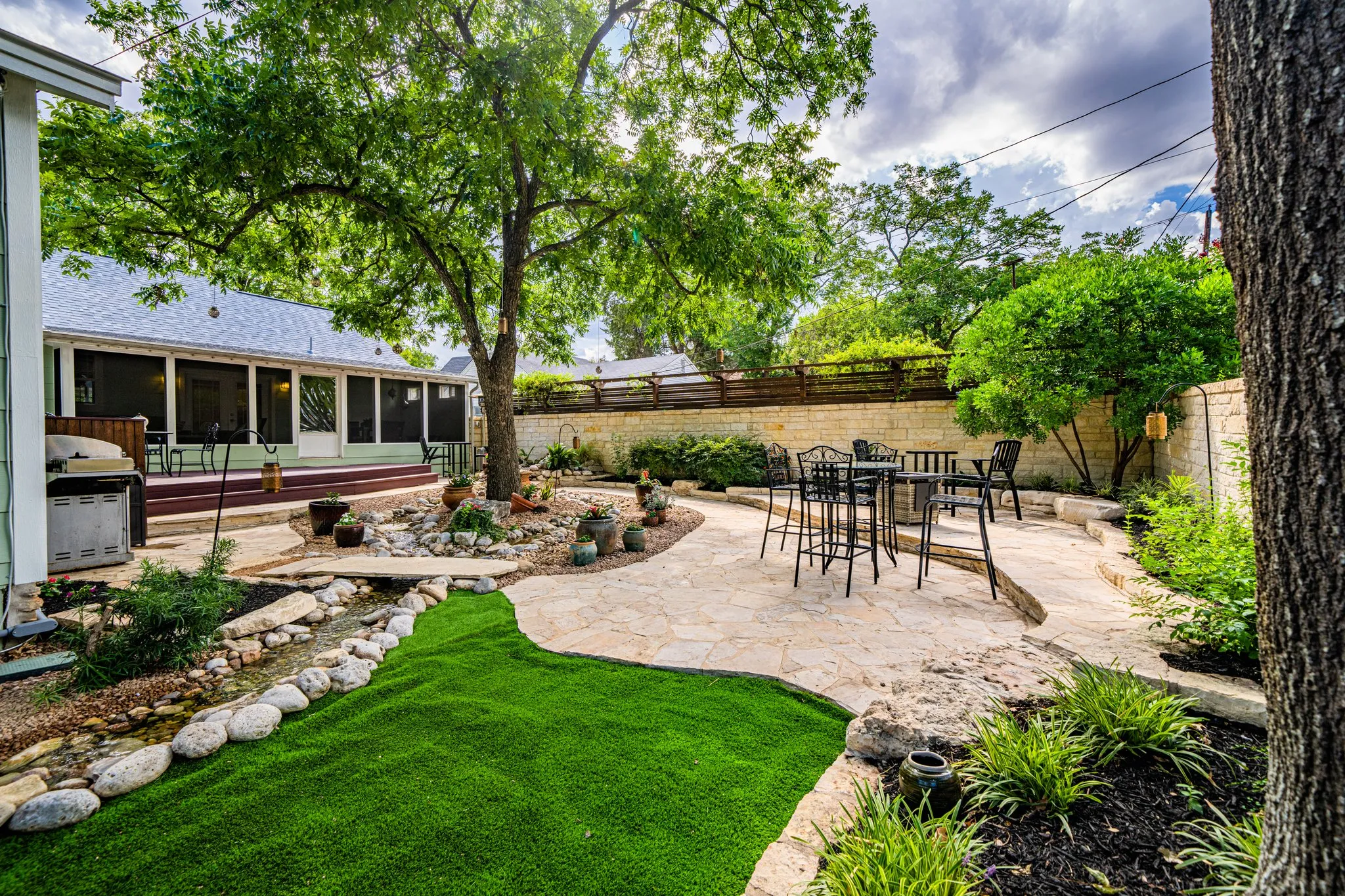 Well-maintained backyard with landscaping, patio, and outdoor dining area at a co-hosted vacation rental
